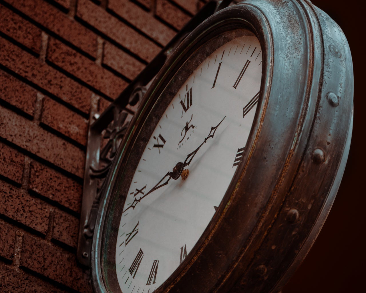 vintage iron clock on brick building