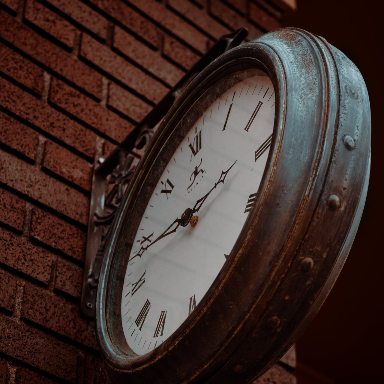 vintage iron clock on brick building