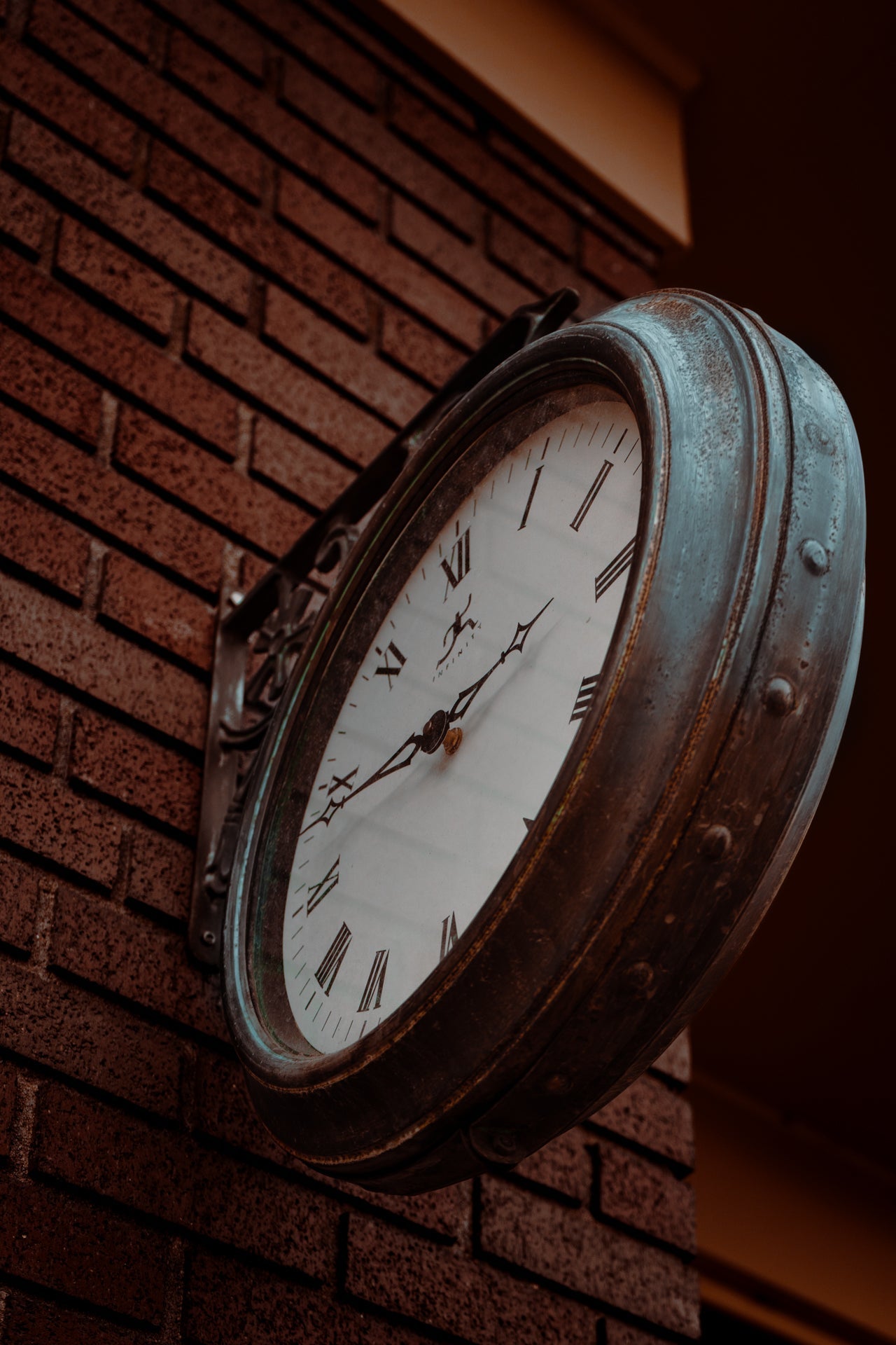 vintage iron clock on brick building