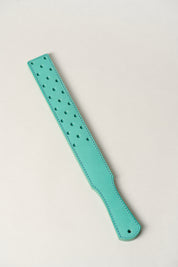 Turquoise leather strap with holes on a light gray background