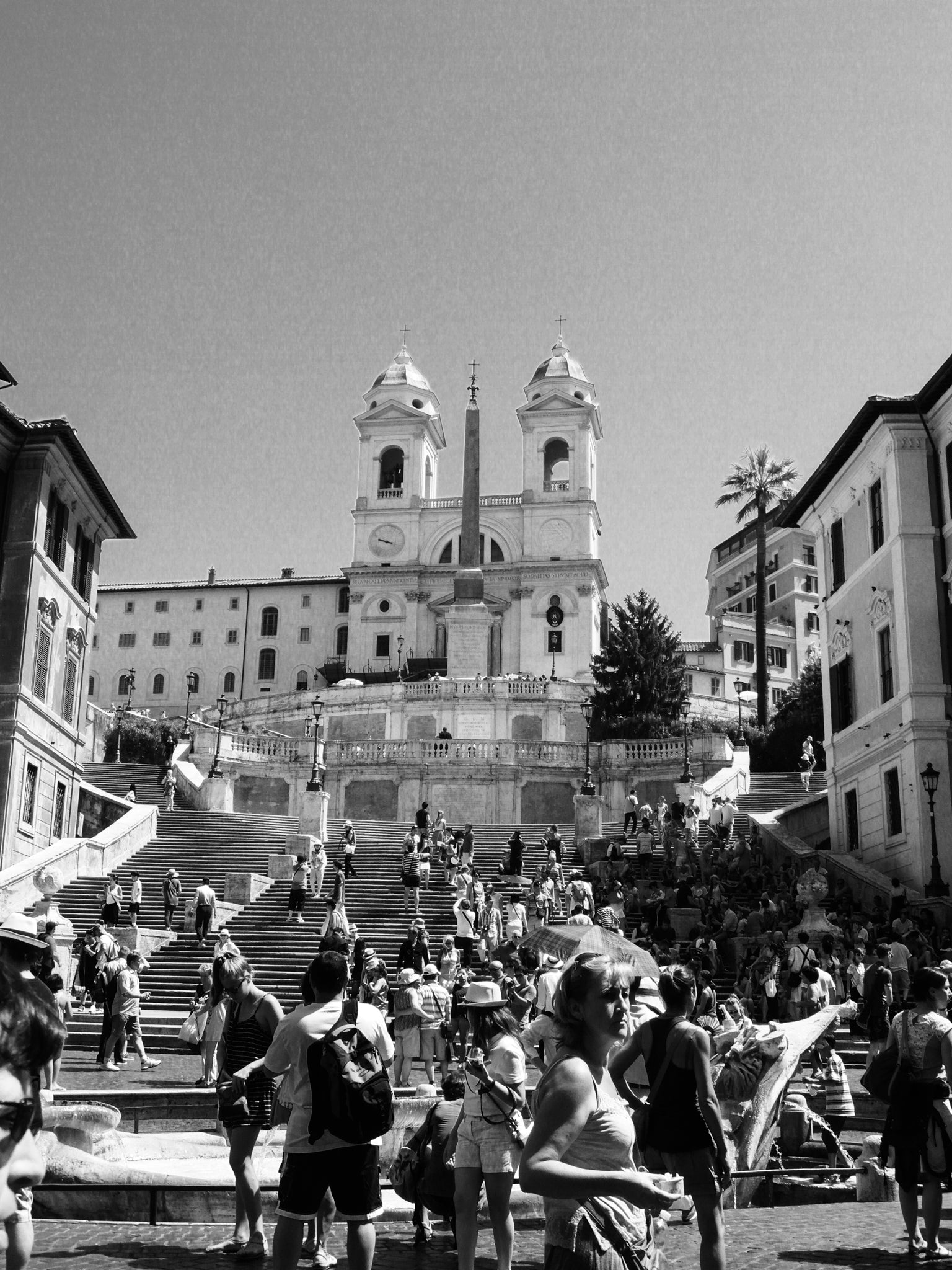 Black and white picture of Piazza di Spagna filled with people in Rome, Italy.