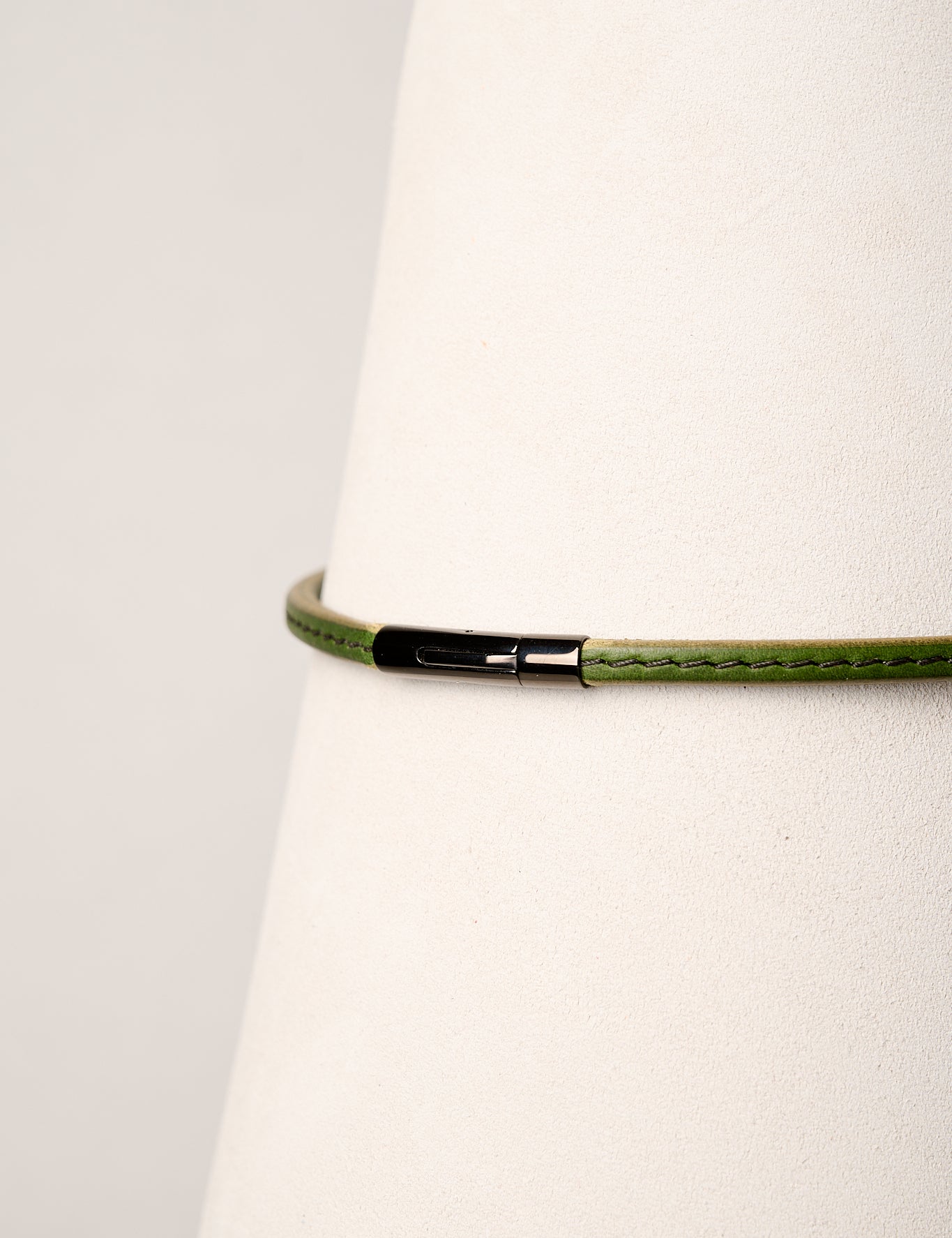 Green necklace with a black clasp on a white background