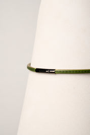 Green necklace with a black clasp on a white background