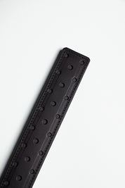 fenestrated black leather strap with black stitching on white background