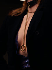Close up of a woman's leather black collar in lingerie with a pendant in the center.