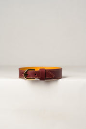 A close-up image of a luxury leather necklace with a gold stainless steel buckle, predominantly burgundy in color.