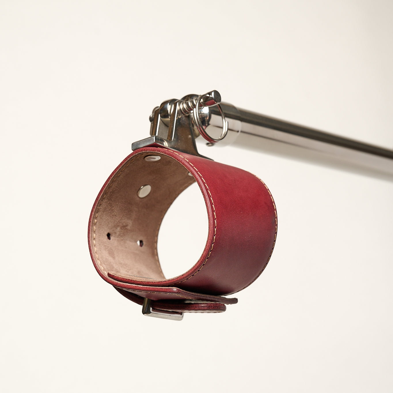 burgundy cuff attached to silver metal bar 