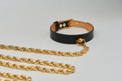 black leather choker necklace gold hardware pendant with chain leash on white background
