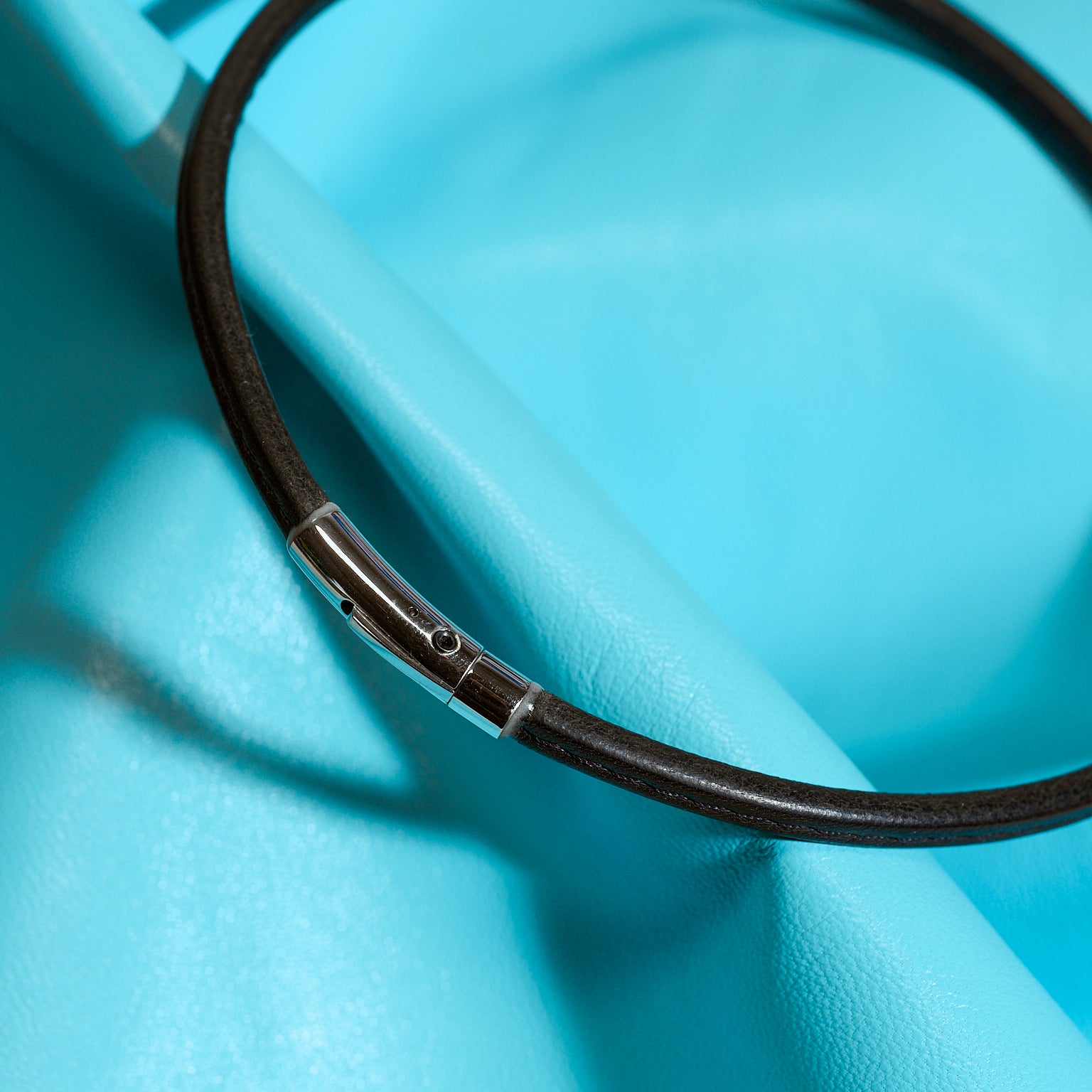 Black leather choker on a blue background