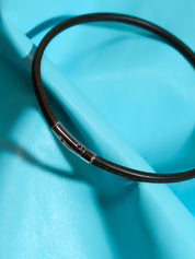 Black leather choker on a blue background