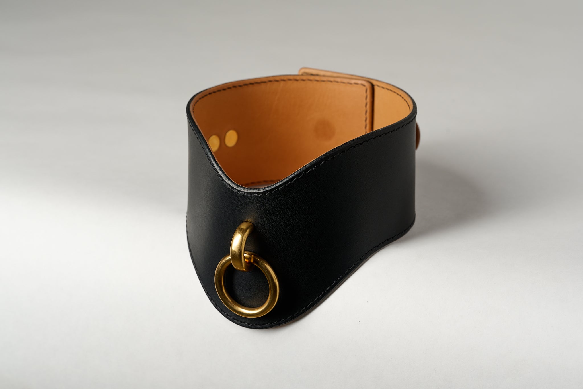 black and light brown leather wide necklace choker with gold pendant on white background