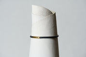 black necklace with a gold clasp on a white background