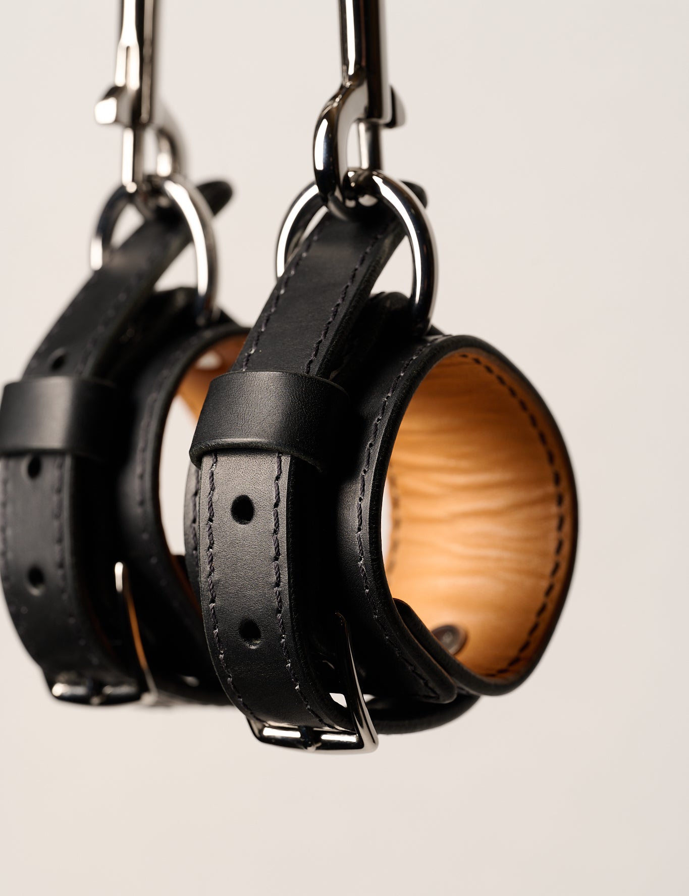 black leather wrist cuffs with silver o rings and chain