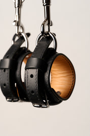 black leather wrist cuffs with silver o rings and chain