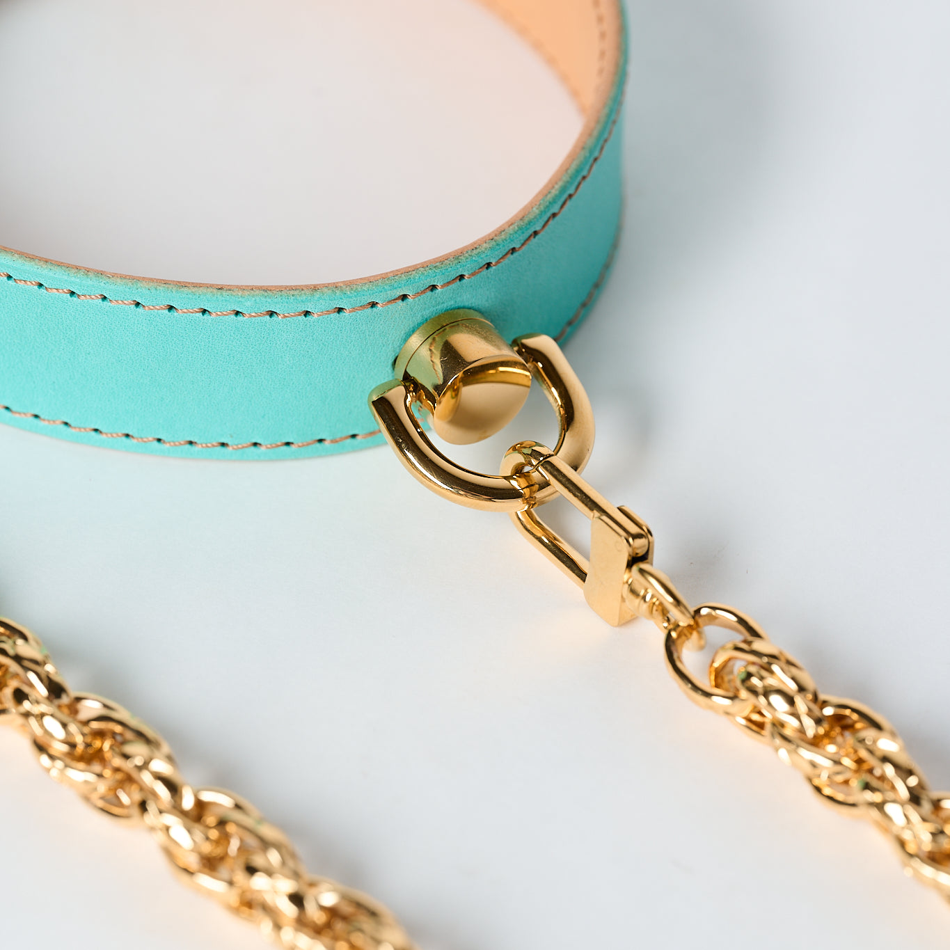 blue leather necklace with gold stainless steel chain and pendant on white background