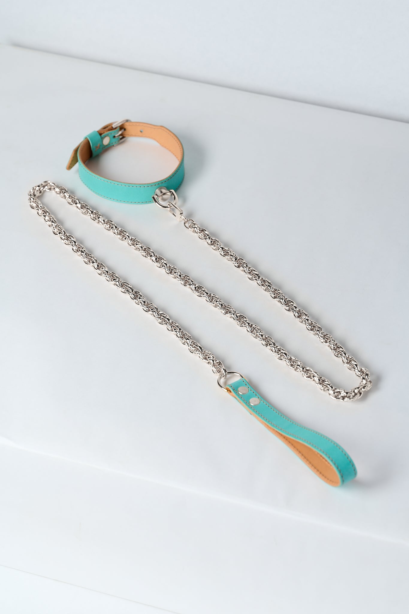 blue leather necklace with silver stainless steel chain and pendant on white background