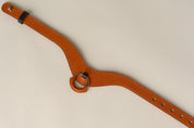 Brown leather necklace with a ring on a beige background