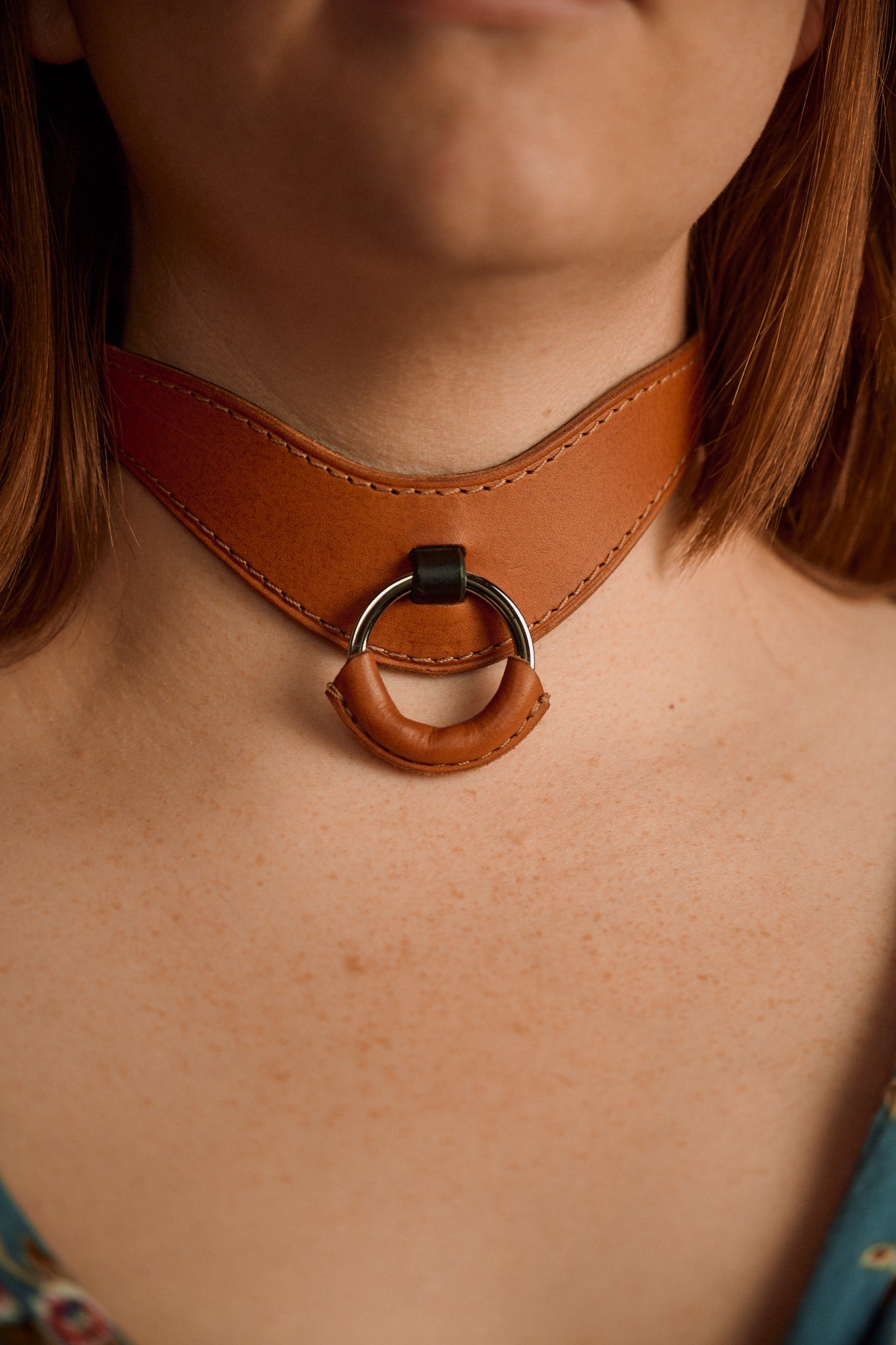brown leather necklace choker with o ring around woman's neck