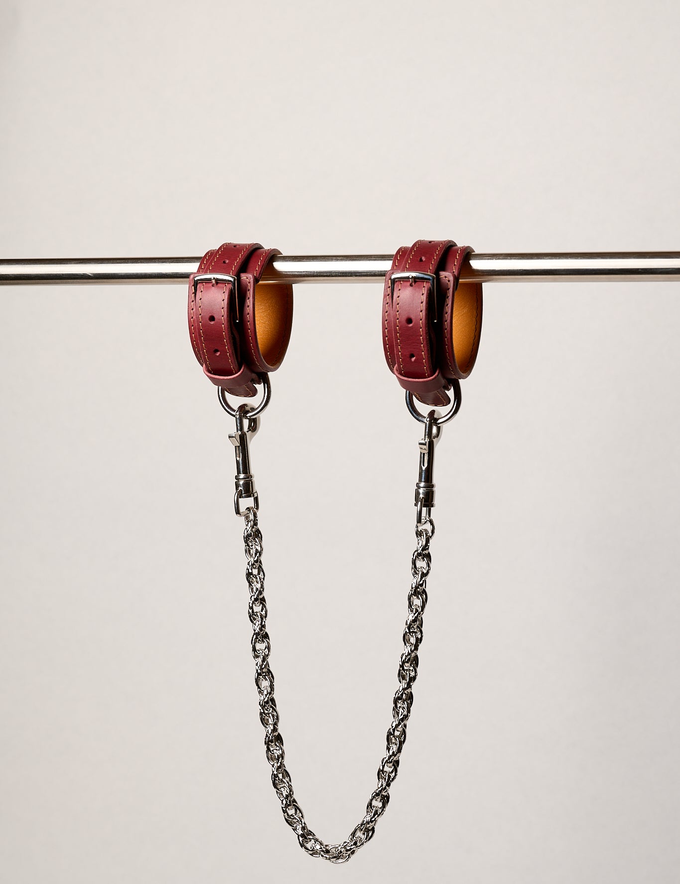Red leatheranklets with chains on a white background