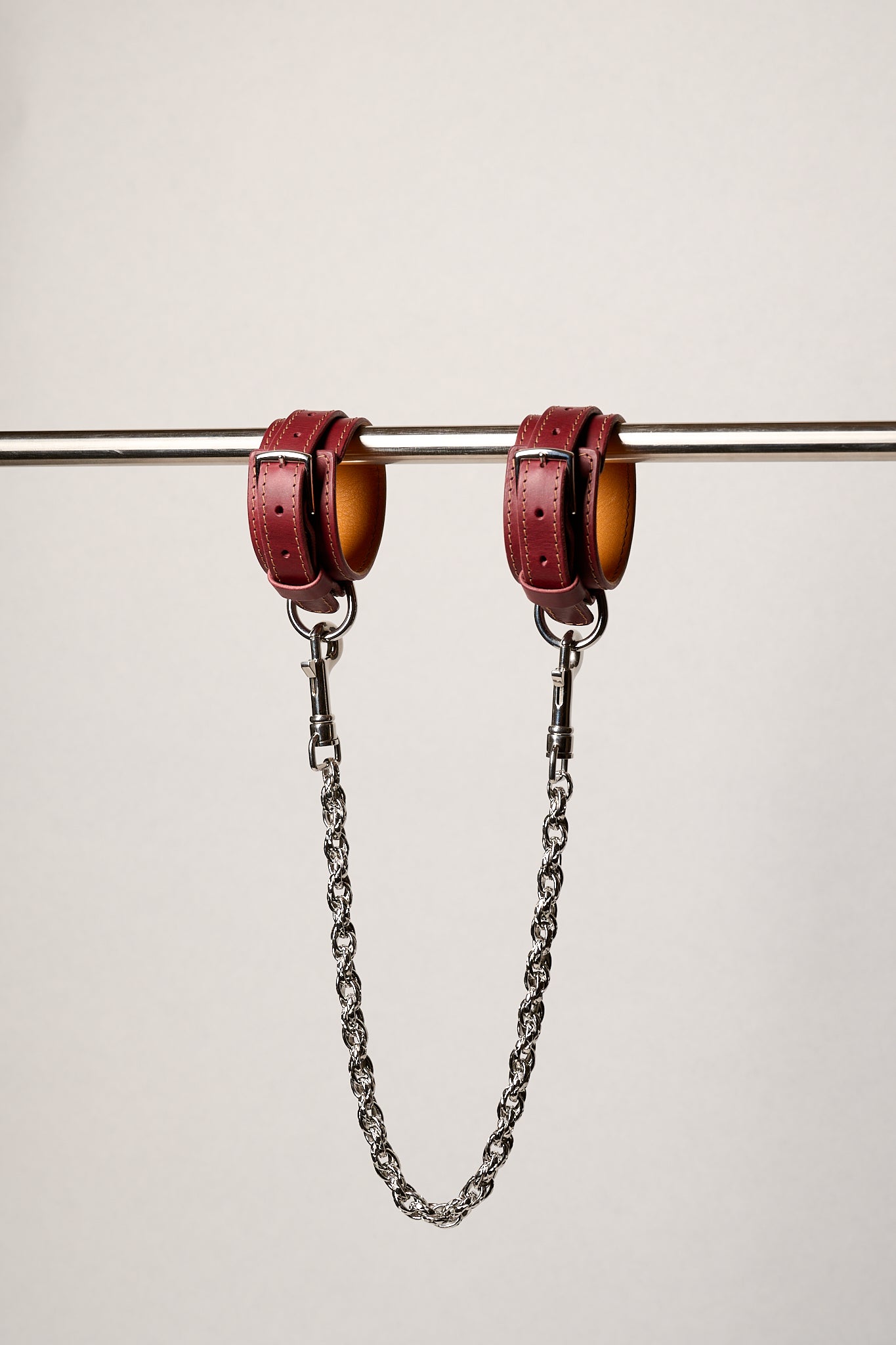 Red leatheranklets with chains on a white background