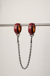 Red leatheranklets with chains on a white background