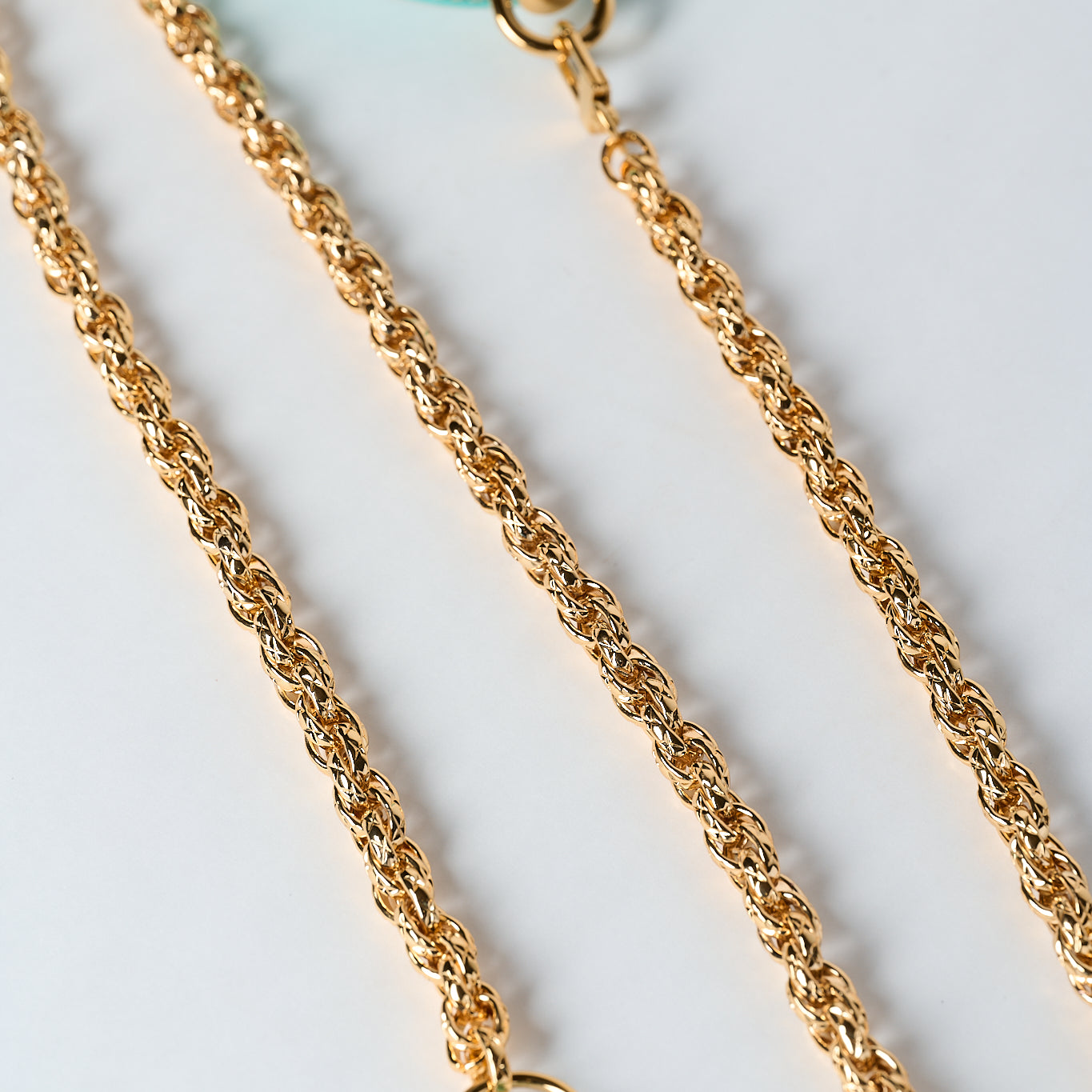 blue leather necklace with gold stainless steel chain and pendant on white background