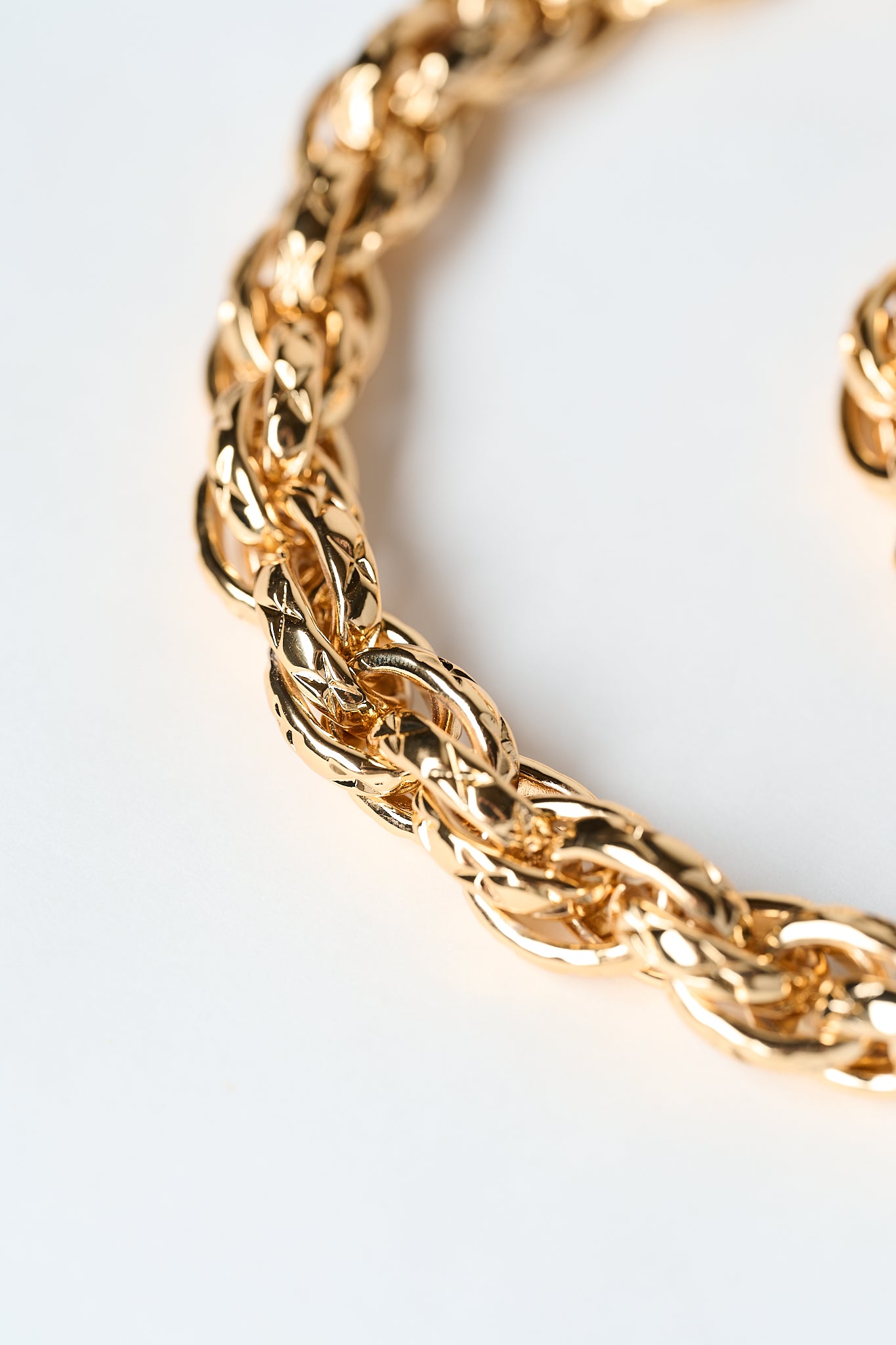 Close-up of a gold chain leash on a light background