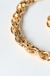 Close-up of a gold chain leash on a light background
