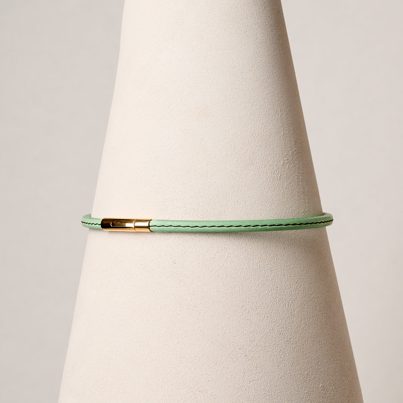 Mint leather necklace with gold clasp on white background