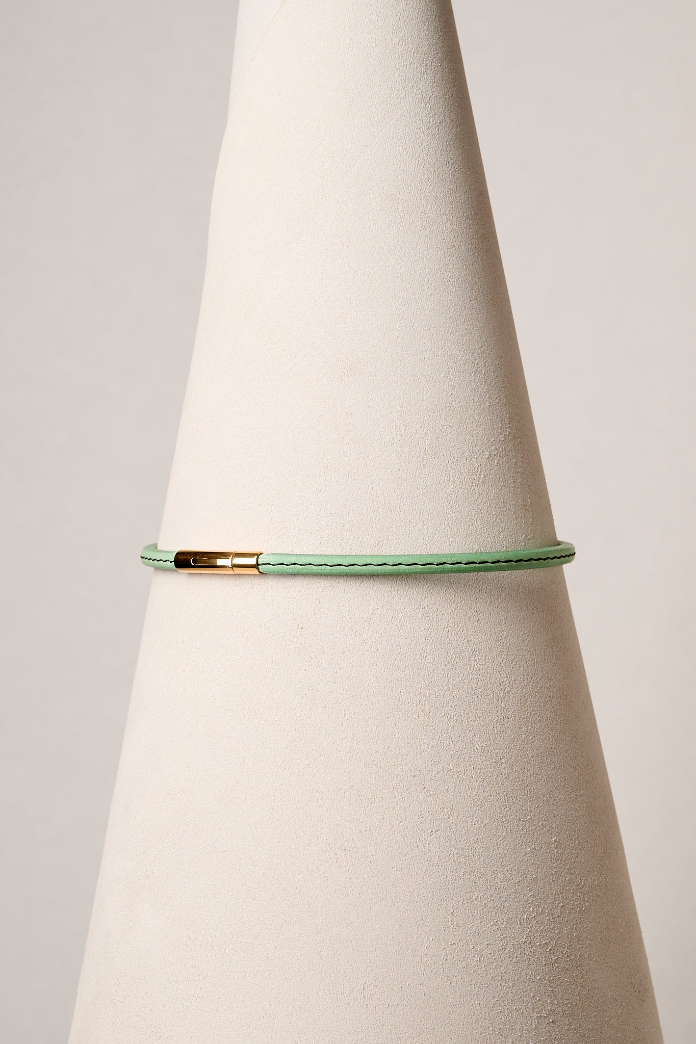 Mint leather necklace with gold clasp on white background