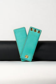 foldable blue leather travel size belt with rivets on white background.