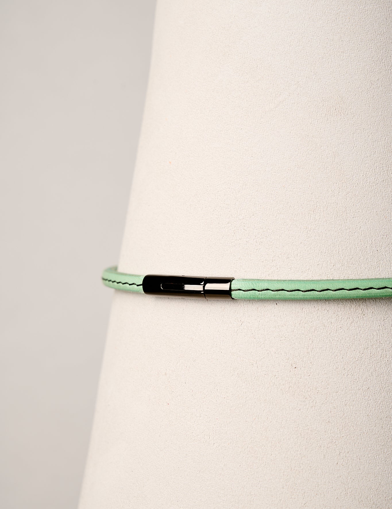 mint necklace with a black clasp on a white background