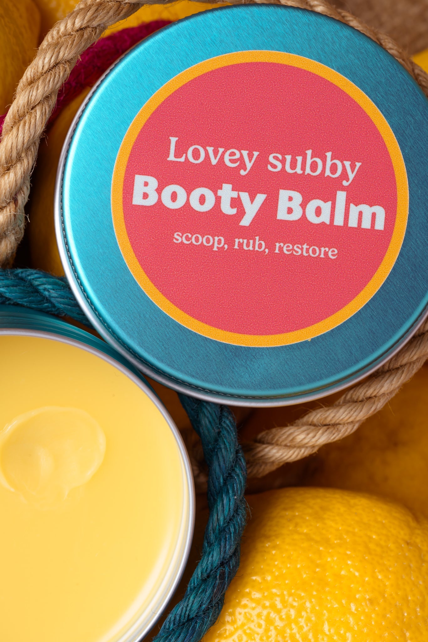 Booty balm container with a colorful label on a textured background