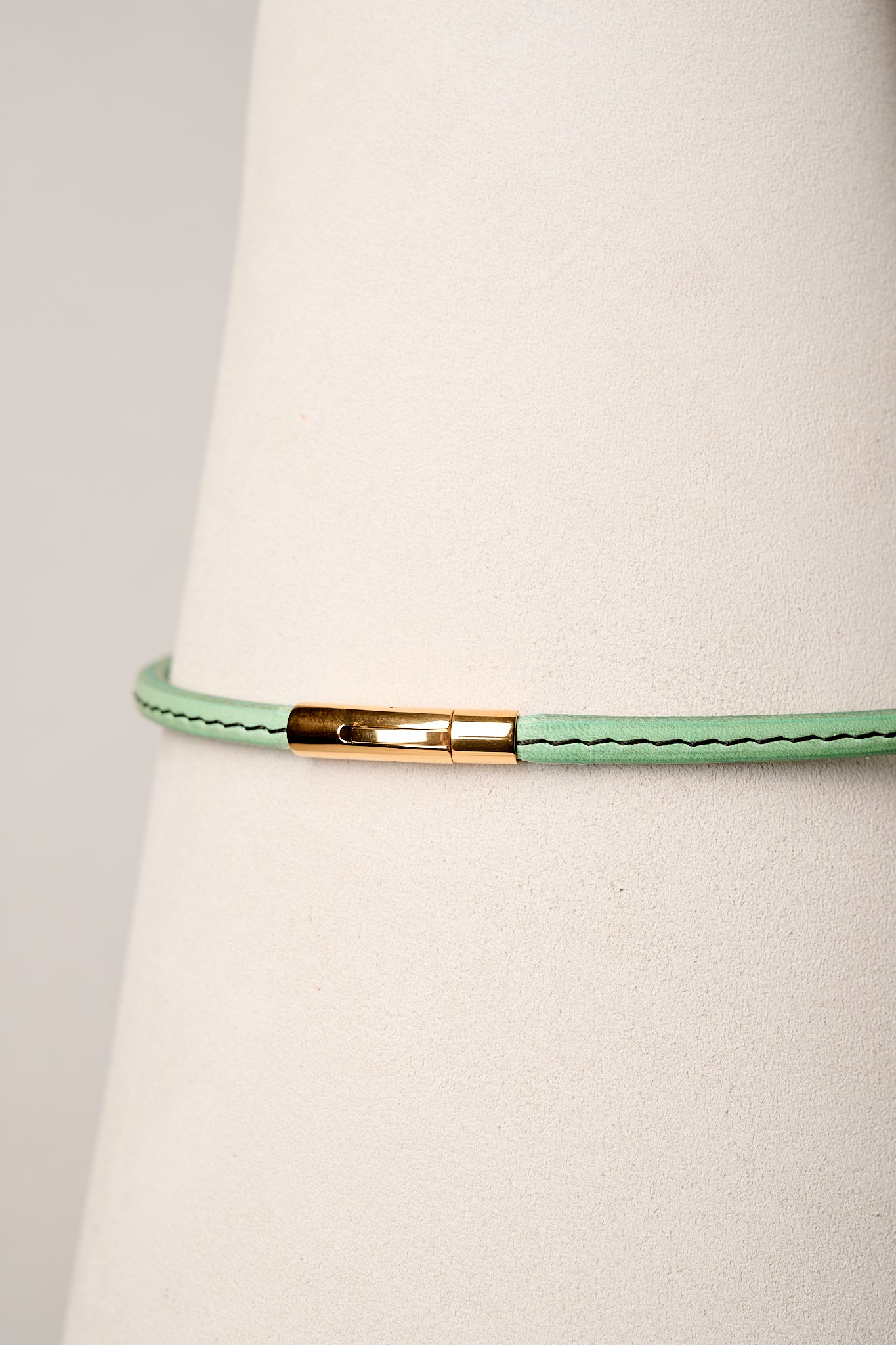 Mint leather necklace with gold clasp on white background