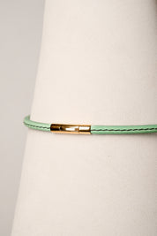 Mint leather necklace with gold clasp on white background