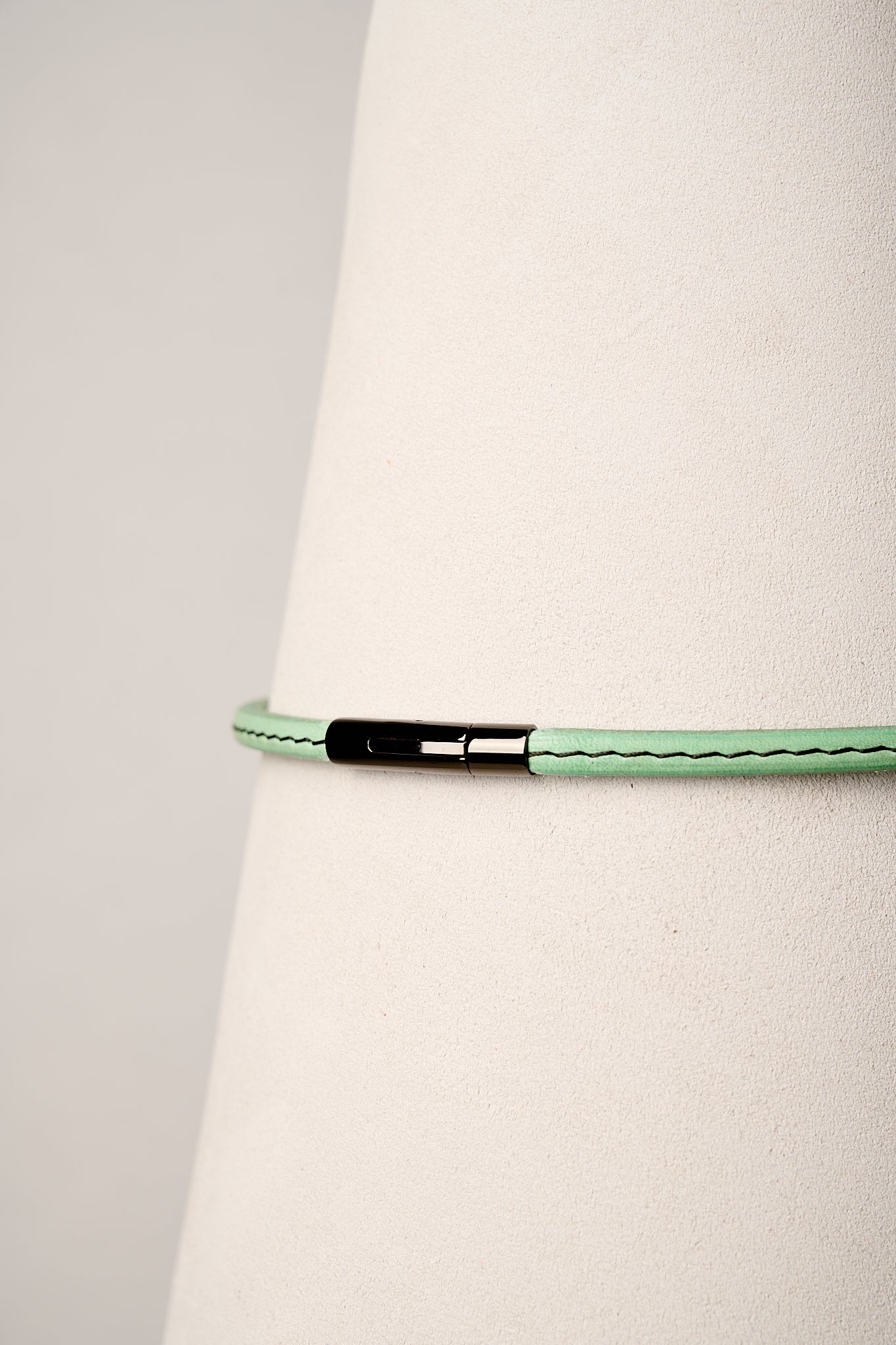 Mint leather necklace with black clasp on white background