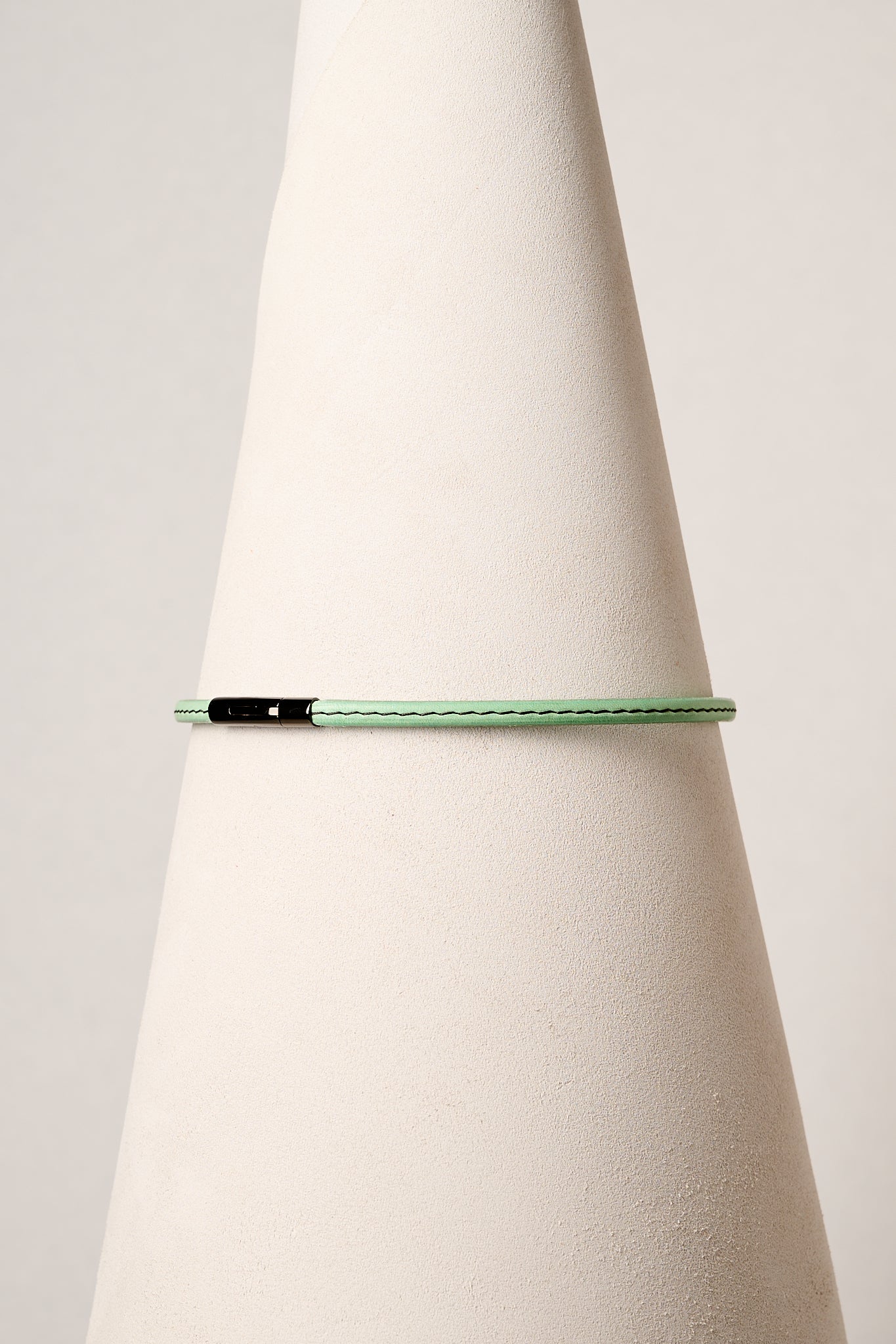 Mint leather necklace with black clasp on white background