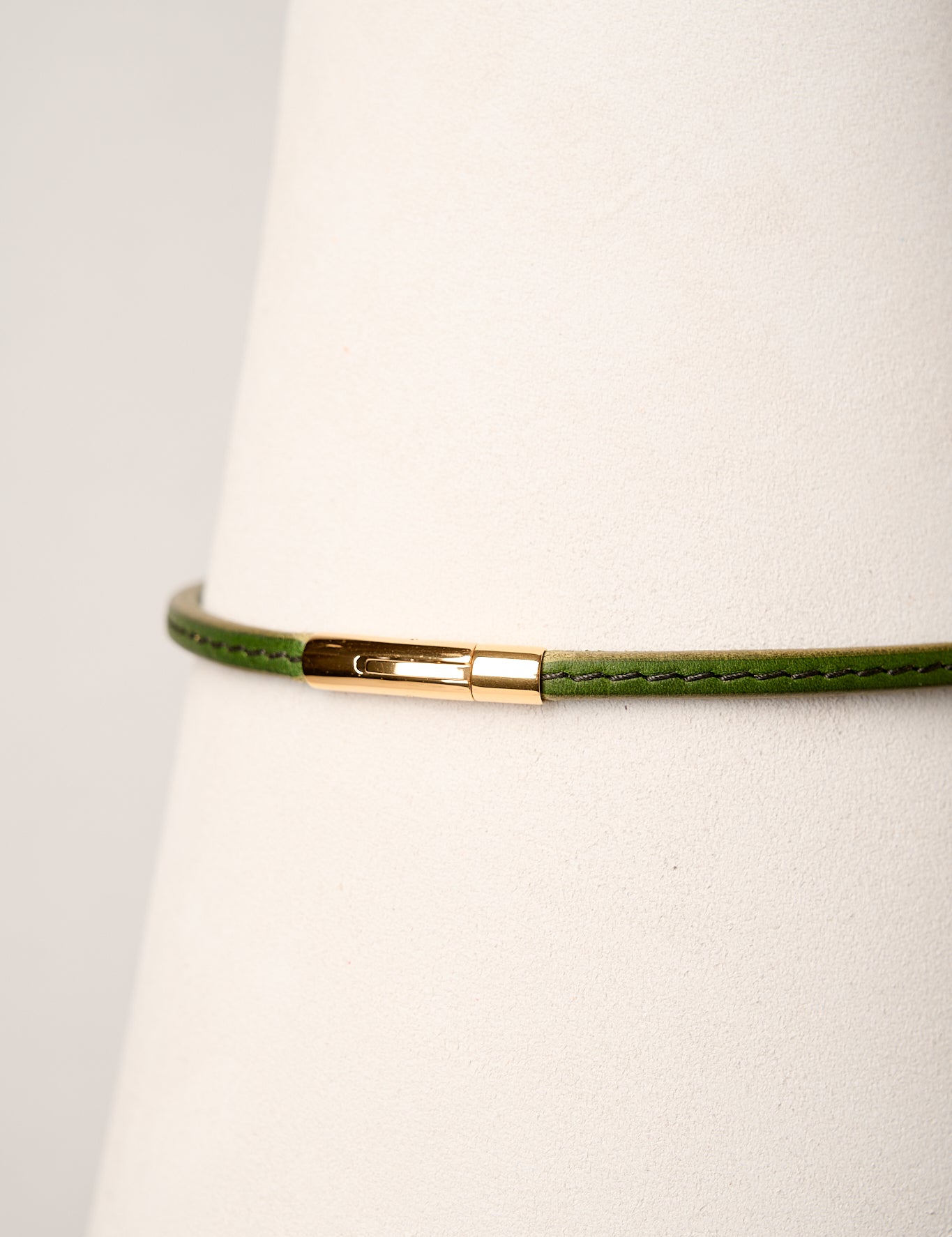 Green necklace with a gold clasp on a white background