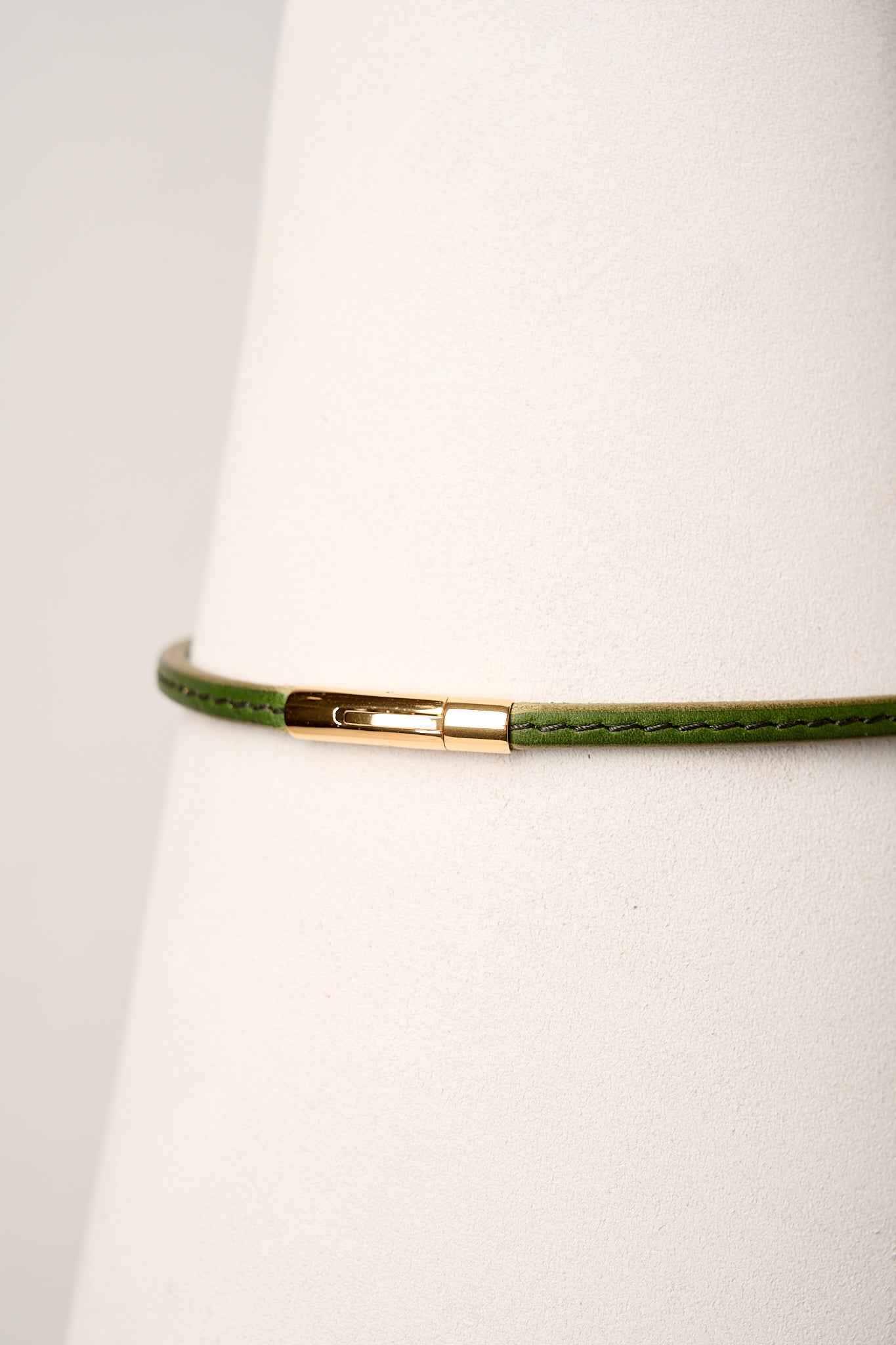 Green necklace with a gold clasp on a white background