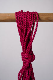 Pink Lovey Subby jute rope looped and hanging on a white background.