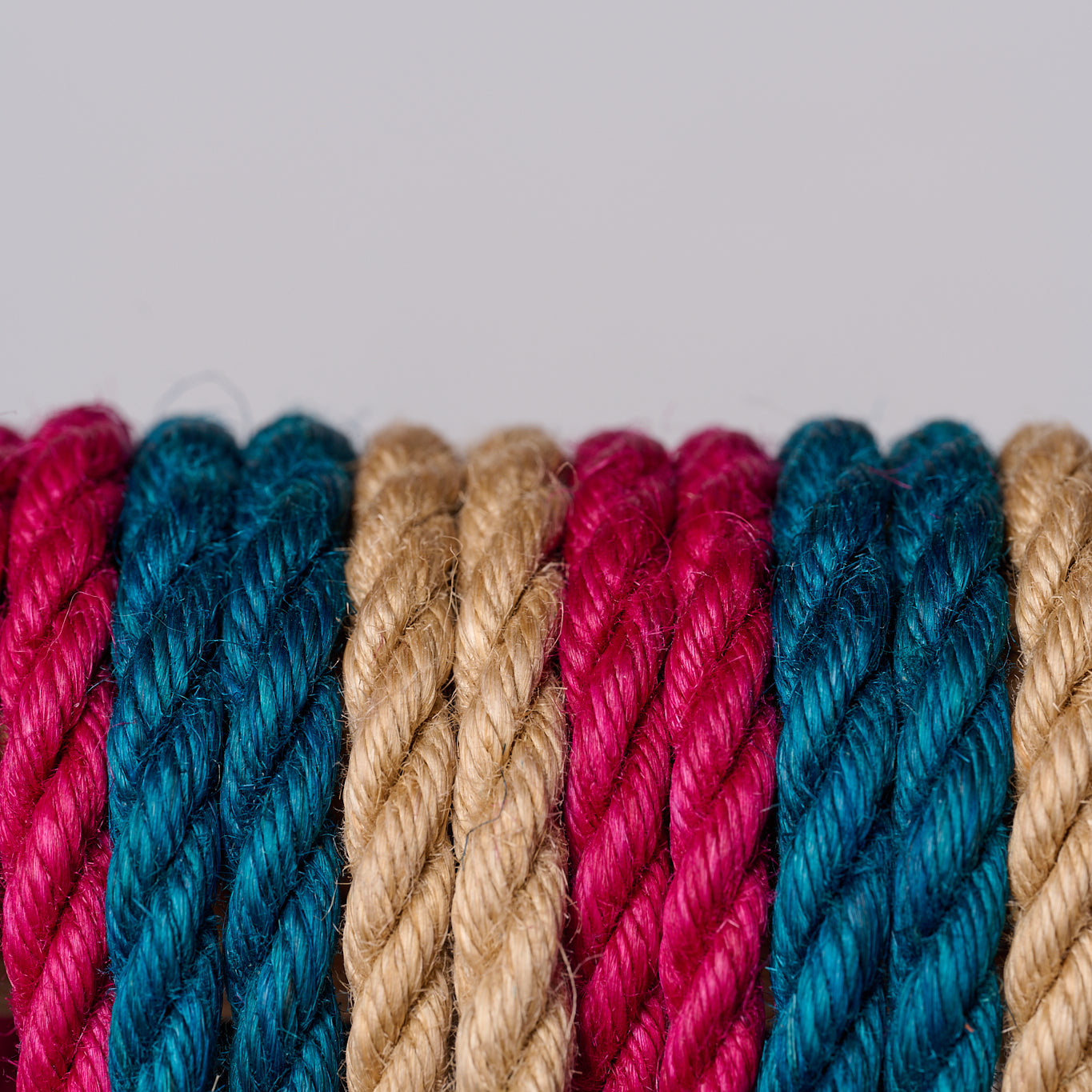 Close-up of multicolored jute ropes on a light gray background
