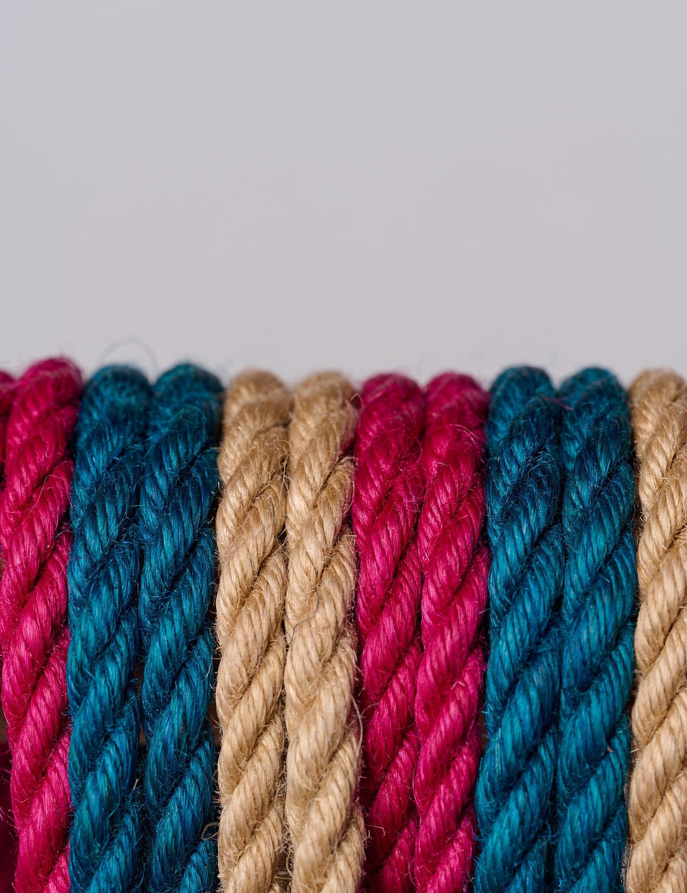 Close-up of multicolored jute ropes on a light gray background