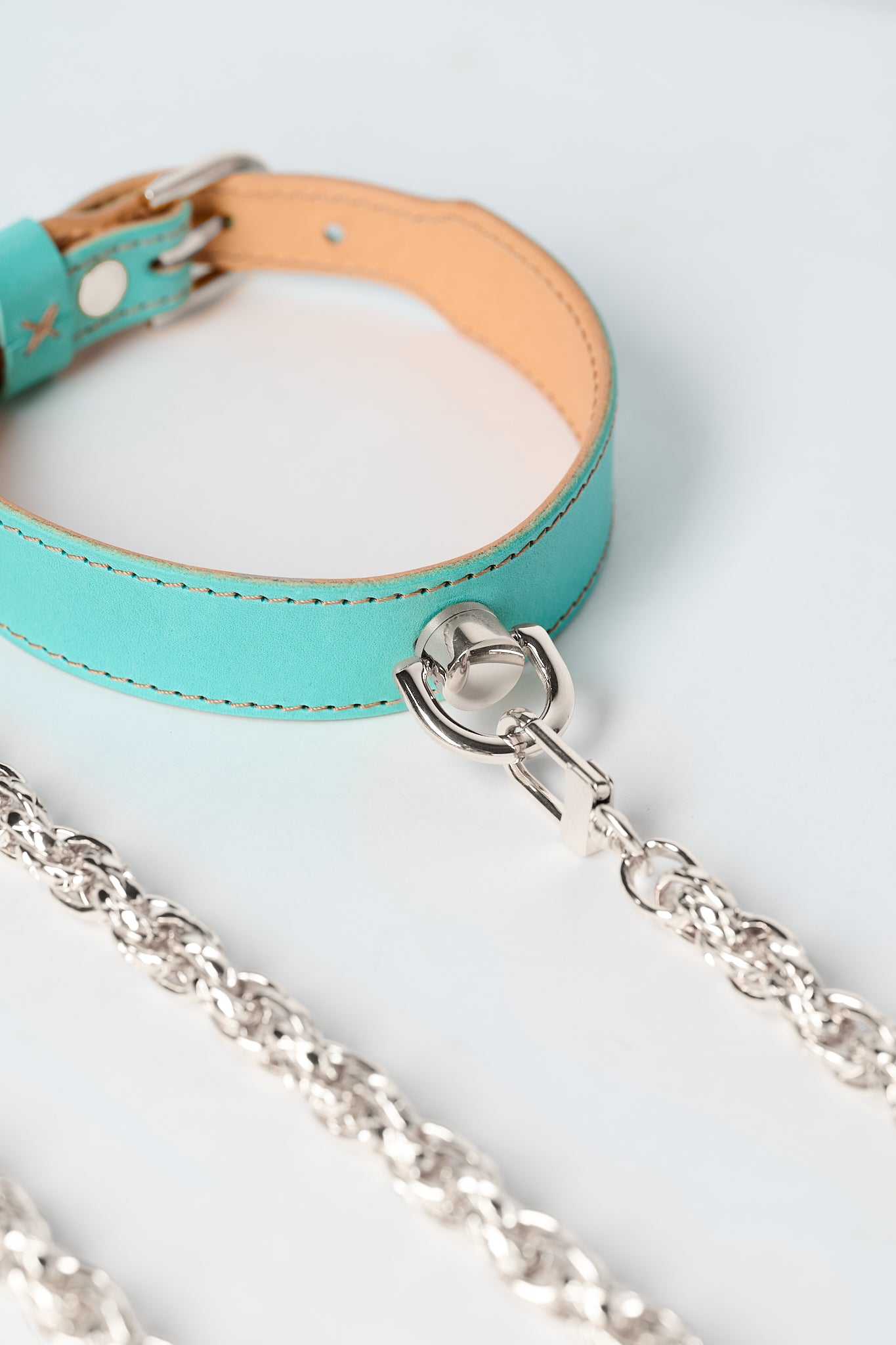 blue leather necklace with silver stainless steel chain and pendant on white background