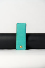 foldable blue leather travel size belt with rivets on white background.