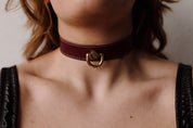 woman in burgundy leather necklace collar with gold pendant